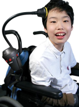 student in a wheelchair using the announcer mounted to wheelchair